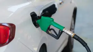Pistolet dystrybutora paliwa wlewa paliwo do baku białego samochodu osobowego