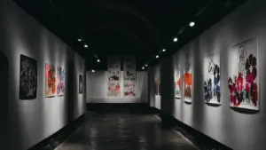 Nowoczesna galeria sztuki z oświetlonymi obrazami w długim, przestronnym korytarzu.