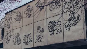Mural z rysunkami znaków zodiaku na elewacji budynku w Krakowie w Polsce.