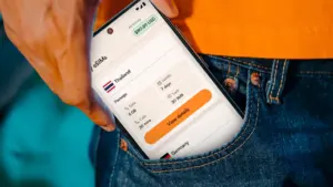 Osoba wyjmująca smartfon z kieszeni z otwartą aplikacją do zarządzania roamingiem