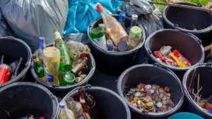 Segregacja odpadów w czarnych wiadrach podczas lokalnej akcji sprzątania terenu.
